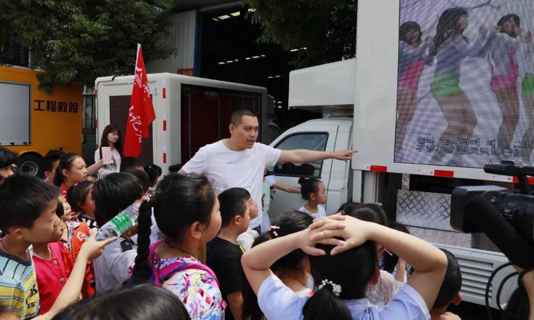 程力电源车专业厂王琼总经理向孩子们认真讲解LED广告车用途和作用